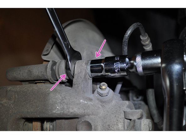 A l'aide d'une douille de 13 mm et d'une clé de 15 mm, déposer la vis supérieure.