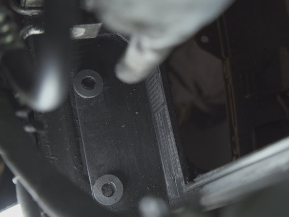 Repérer les deux guides sur le bas du radiateur et leurs logements dans l'emplacement