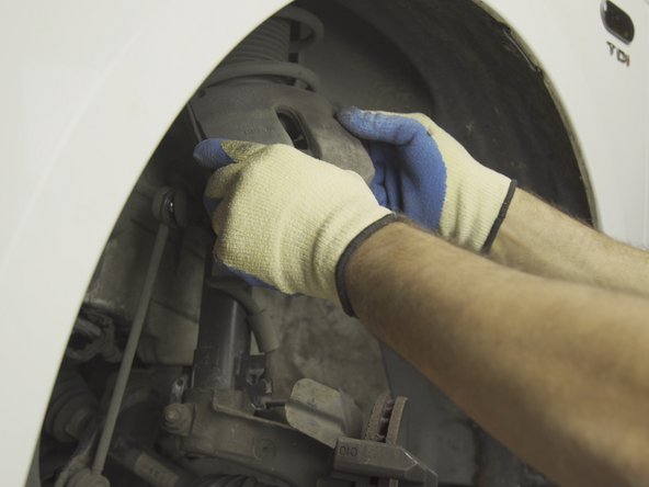 Caler l'étrier sur la jambe de force afin de ne pas faire pendre l'étrier par son flexible de frein