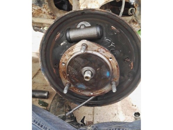 Pousser le cylindre de roue vers l'intérieur de la flasque puis terminer le dévissage du flexible en tournant le cylindre de roue