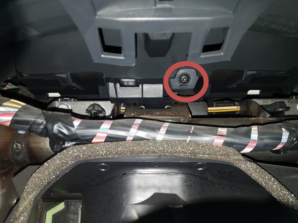 Deviser la vis de fixation de la visière du combiné d'instrument puis déposer celle-ci.