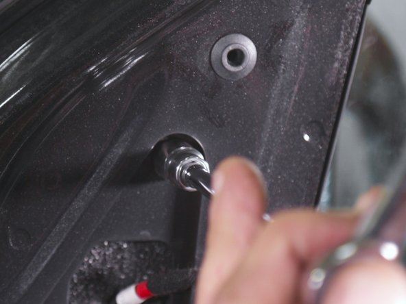 Al'aide d'un petit cliquet et d'une douile de 10 desserrer les trois vis retenant le rétroviseur