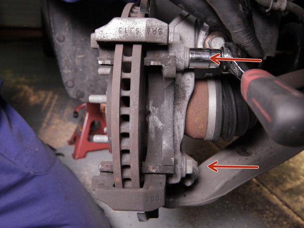 Dévisser les deux vis de la chape, derrière le disque à l'aide du cliquet et d'une douille de 18