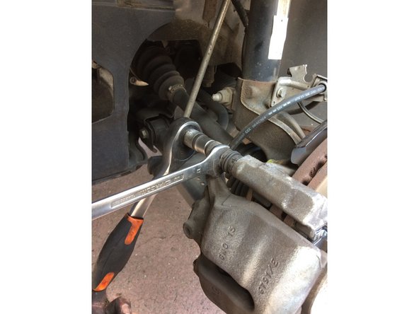 Maintenir la vis 2 à l'aide de la clé plate puis dévisser la vis 1 (en haut et en bas)