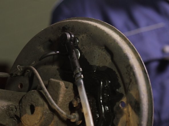 Brancher le bidon purgeur dans l'emplacement dédié derrière la flasque, juste au dessus du câble de frein