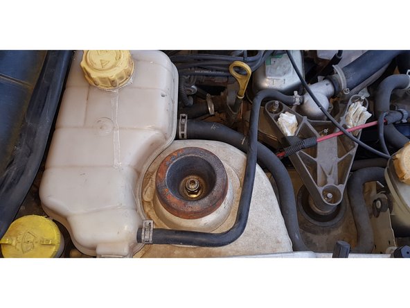 Avec une clé à œil coudée de 18mm et un embout BTR 6mm, retirez l'écrou.