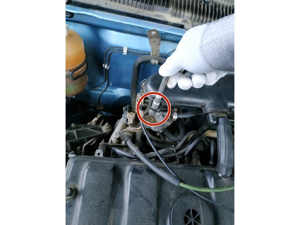 retirer la vis de fixation de la coiffe du carburateur à l'aide de la clé de 10mm