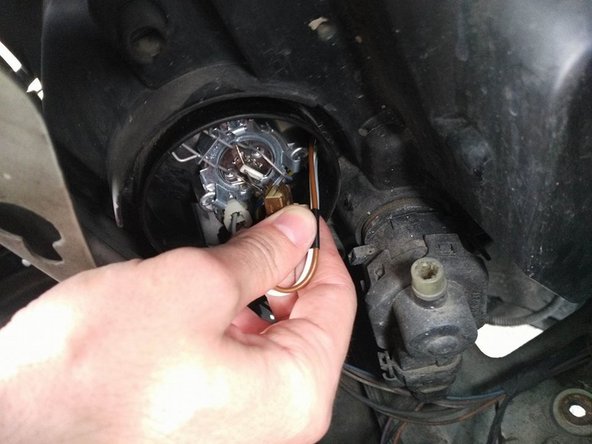 Repositionner le support d'ampoule dans l'emplacement prévu et replacer les épingles afin de verrouiller la position du support d'ampoule