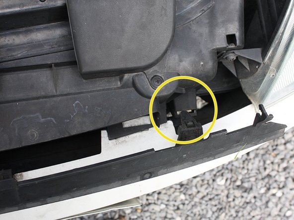 Placer d'abord les crochets de la partie inférieur de la calandre.