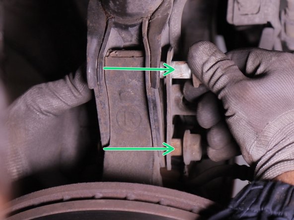 Retirer les deux vis de l'autre côté tout en récupérant la plaque de support de flexible de frein