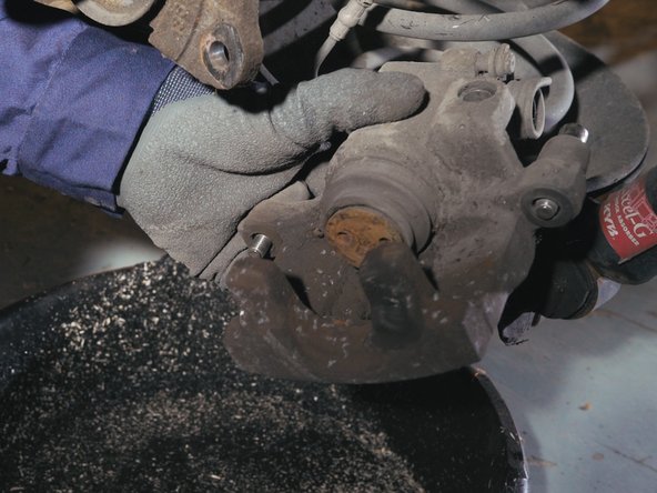 Appliquer du nettoyant frein sur l'étrier de frein et nettoyer l'étrier avec une brosse métallique