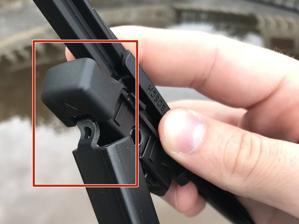 Positionner le crochet de l'essuie-glace dans la tête du balai (la flèche vous indique comment insérer le balai)