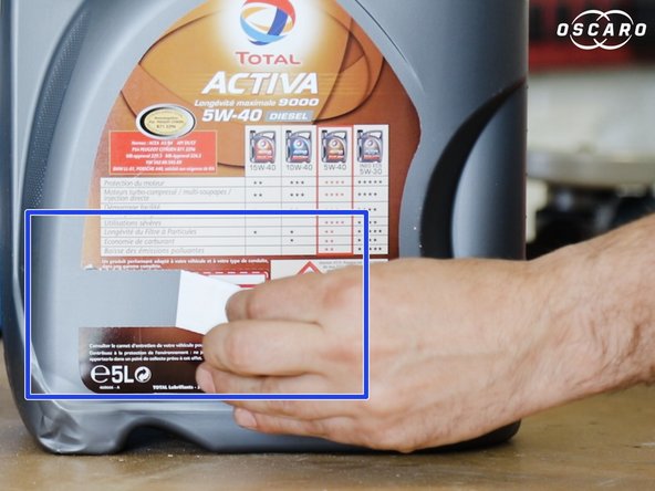 Retirer l’étiquette qui se trouve derrière le bidon d'huile