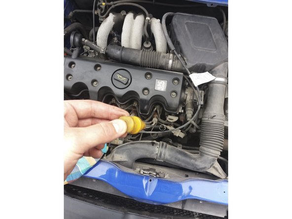 Le véhicule étant bien à plat, effectuer une première jauge pour vérifier que le niveau d'huile dépasse l'encoche minimum (flèche verte).