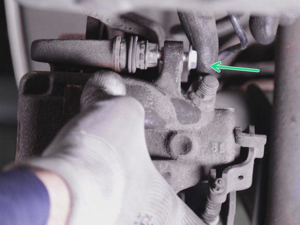 Repositionner et visser les deux vis de l’étrier en  commencent par celle du haut puis maintenir en pression l'étrier contre les ressorts de plaquettes pour insérer la seconde