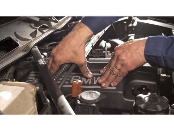 Glisser le cache moteur sous les supports de faisceaux et la barre de renfort