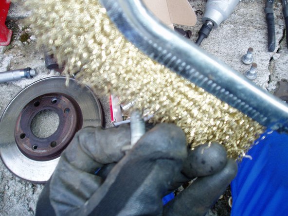 Nettoyer les vis de maintien de l'étrier et du maintien de support des plaquettes à l'aide d'une brosse métallique