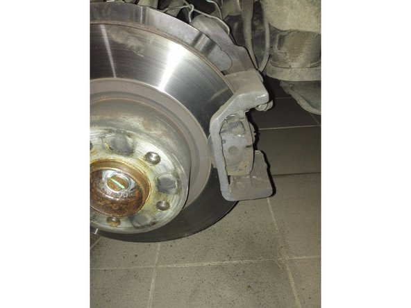 Photo1: une fois l'étrier de frein ouvert, on retire les plaquettes à l'aide d'un tournevis plat. Le câble de témoin d'usure est fixé sur la plaquette intérieure.