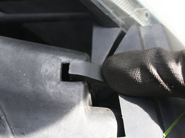 Finir en replaçant les crochets supérieurs de la calandre.