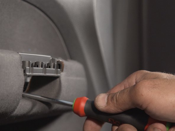 Dévisser les 2 vis se trouvant derrière la poignée à l'aide d'un tournevis Torx 30