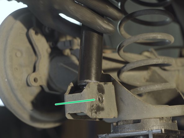 Aligner les trous et placer la longue vis de maintient de l'amortisseur