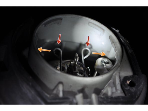 Appuyer puis écarter vers l’extérieur les deux clips de maintien de l'ampoule