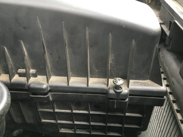 Reposez le cache filtre à air comme a l'origine. Les quatre trous doivent être alignés afin de réussir à visser le vis.