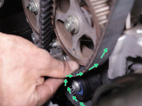 Passer la courroie au dessus du galet enrouleur pour l’amener sur la poulie d'arbre à cames d'admission puis vers la poulie d'arbre à cames d'échappement