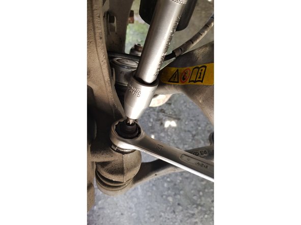 Bloquez la tige filetée avec une douille torx T40 puis dévissez l'écrou avec une clé à œil de 21mm.