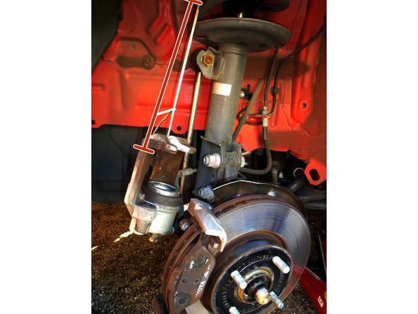 Une fois les 2 vis enlevées, démonter  l'étrier de frein et l'accrocher avec du fil de fer sur le ressort de l'amortisseur.