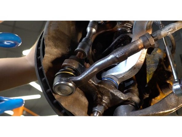 Vissez l'écrou de fixation reliant l'embout de biellette à la fusée d'essieu. Utilisez une douille n° 21. Utilisez une clé à cliquet.