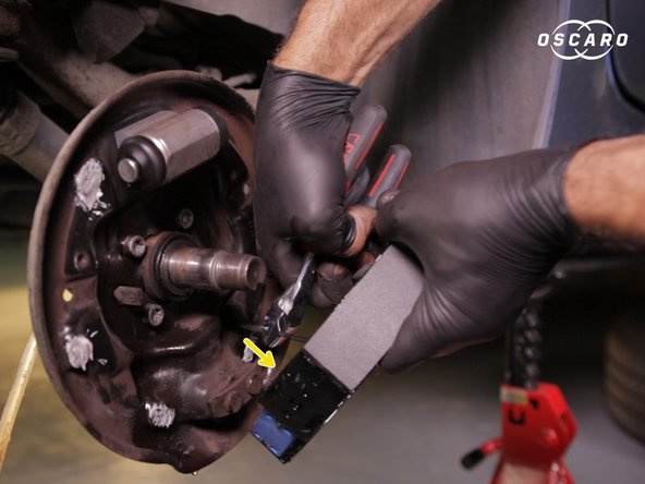 Replacer le câble de frein à main dans le crochet sur les mâchoires