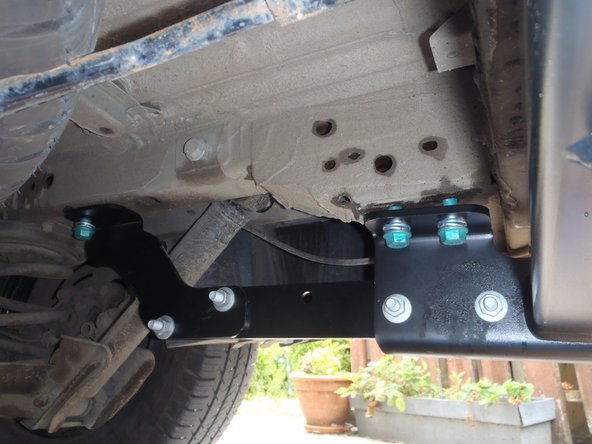 Toujours avec quatre vis, rondelles et écrous. Visser à la main.