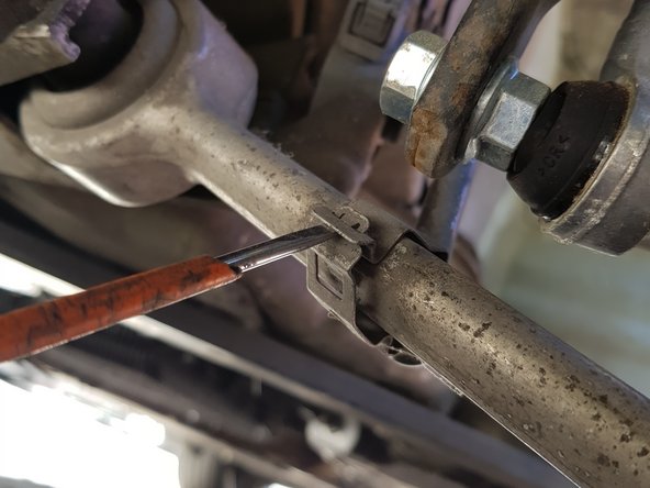 Insérez un petit tournevis plat dans l'agrafe puis faîtes levier pour la détacher.