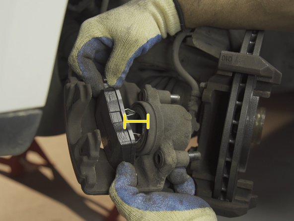 Installer la plaquettes de l'étrier en plaçant le système d'accroche dans le piston