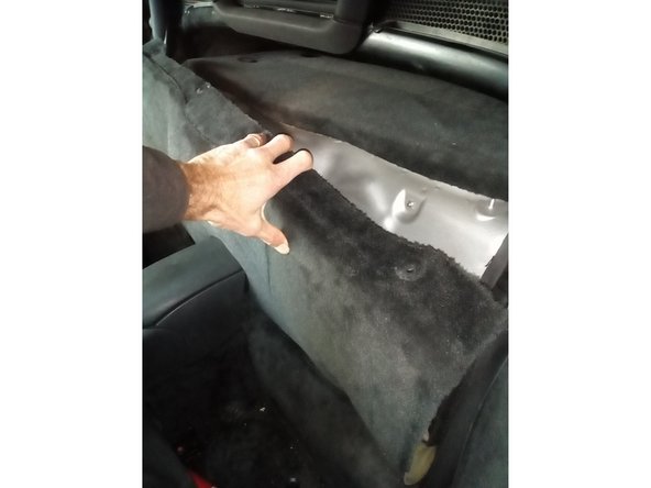 Déposer le morceau de moquette qui cache la trappe d'accès au moteur en commençant par le haut.