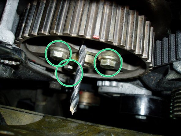 A l'aide d'une clé de diamètre 13, dévisser et déposer le galet enrouleur (cercle jaune).