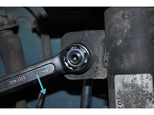 Serrer l'écrou autofreiné de la biellette supérieure avec la douille de 17 mm.