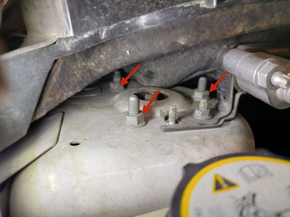 Dans le compartiment moteur, déposer les 3 écrous de fixation supérieure avec une clé de 13.