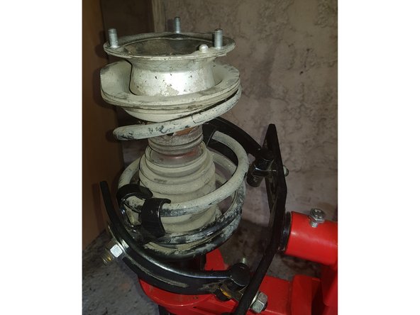 Compressez le ressort jusqu'à ce que la coupelle soit libre.