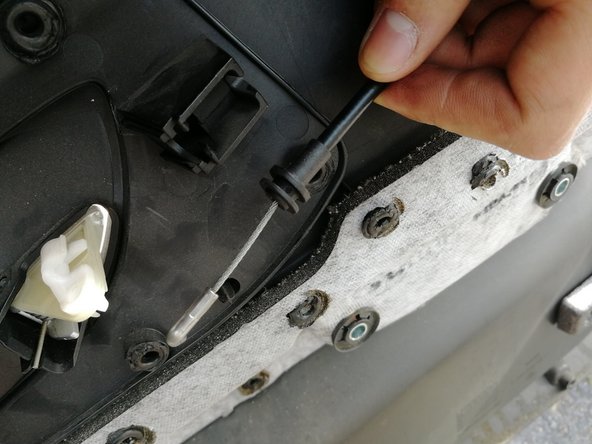 A ce stade le câble de la poignée de porte est décroché de la garniture.