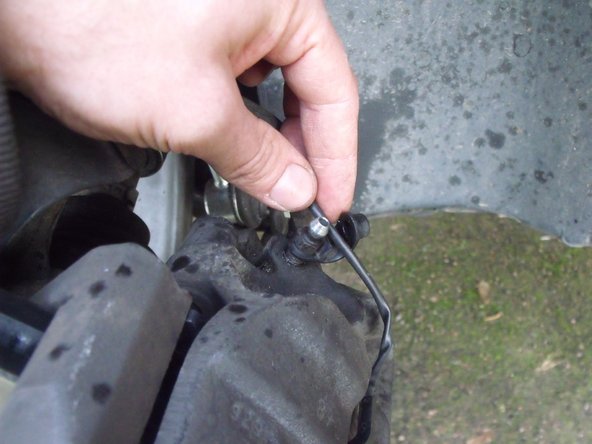 Une fois la purge de l'étrier avant droit terminée, ne pas oublier de remettre le câble du témoin d'usure des plaquettes de frein dans son attache.