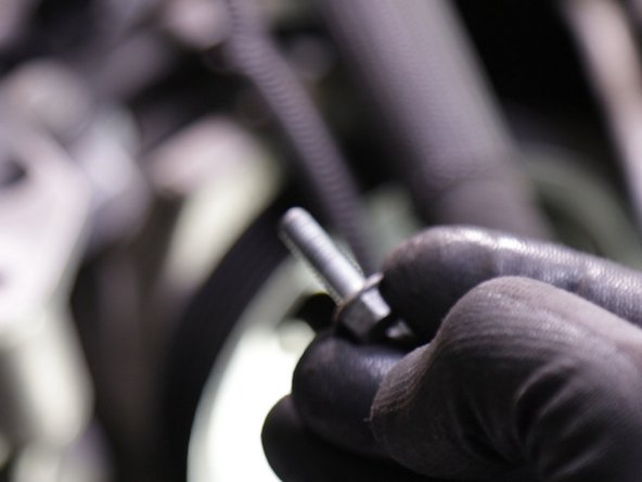 Retirer les deux vis du haut du carter en plastique avec une clé de 10 (ici la première en haut à droite)