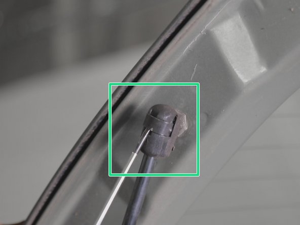 Placer le tournevis plat entre le clips et l'attache retenant le haut du  vérin