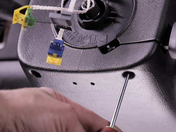 Desserrer les deux vis se trouvant dans la coquille inférieur du volant à l'aide d'un torx T20, ces vis ne se retirent pas