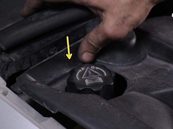 Replacer le cache du lave glace et liquide de refroidissement puis repositionner les deux attaches