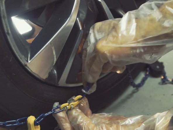 Refermer la partie intérieur de la chaîne bleu du tendeur sur le crochet jaune à gauche en bas de la roue