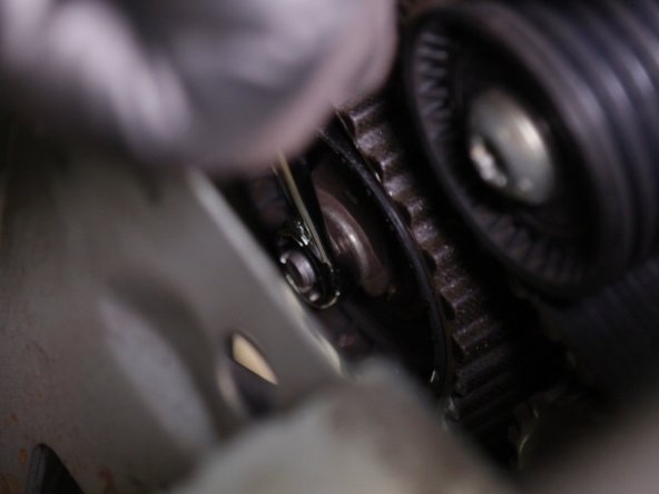 Desserrer l'écrou du galet tendeur avec une clé de 13