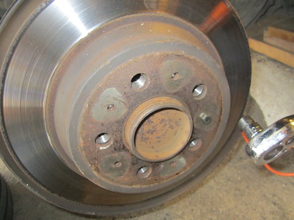 A l'aide d'une clé à cliquet et d'une douille de 10mm, dévisser la vis retenant le disque. Si celui résiste (calamine), revisser un goujon de roue et taper avec un marteau un coup sec au centre du disque, démonter ensuite celui-ci.