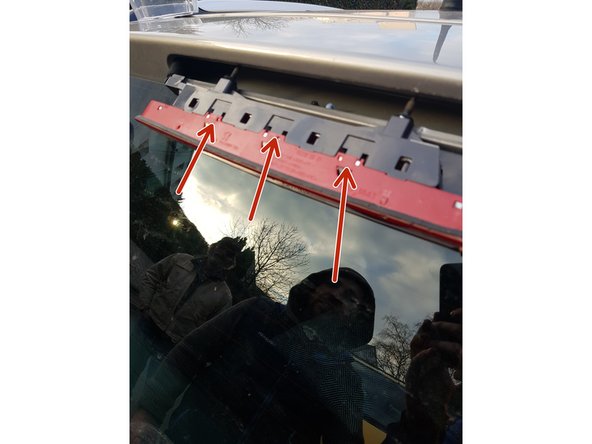 Maintenant, 3 clips sont présent sur le dessus du plastique du feu stop, utilisez un petit tournevis plat pour appuyer sur les clips et tirer vers vous pour séparer les 2 parties du troisième feu stop.